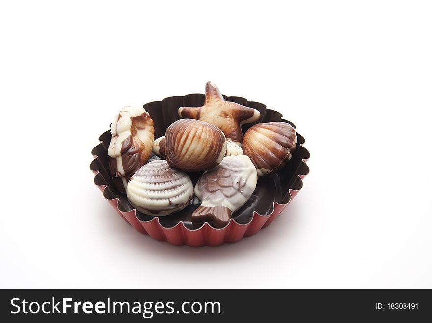 Mussel chocolates onto white background