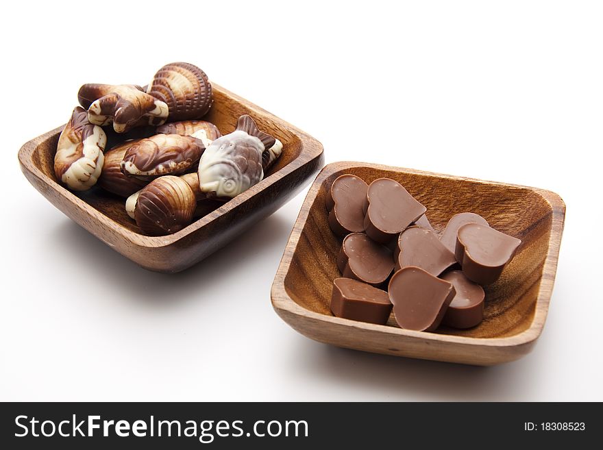 Chocolates with heart in the wood bowl