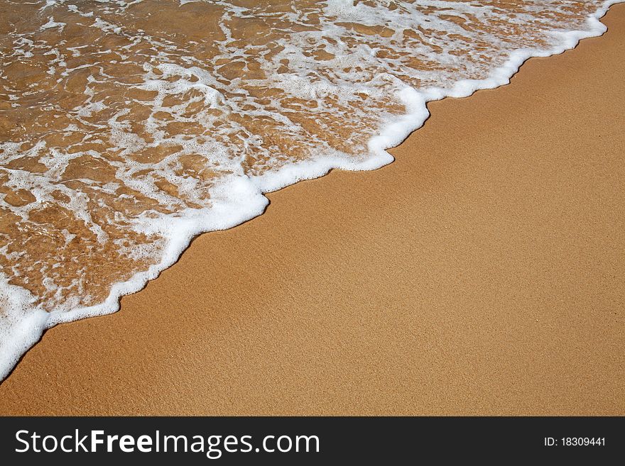 Sandy beach and water wave background