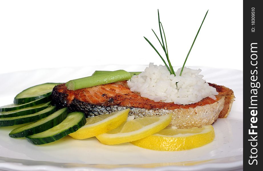 Fried salmon with vegetables on white background