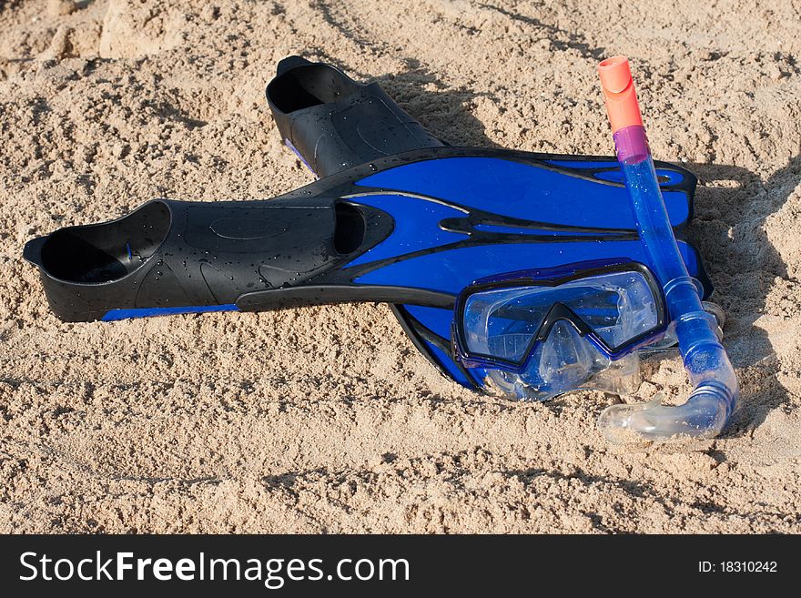 Swimming flippers and mask on the sand