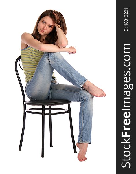 Girl in green stripy top sit on stool touchs hair. Isolated on white.