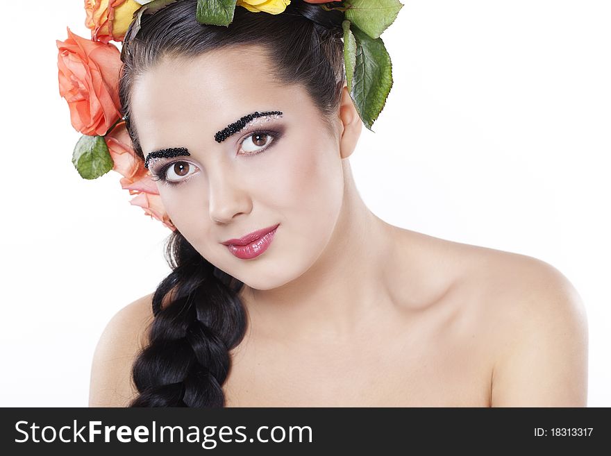 Portrait of young beautiful woman with roses in hair, on white background