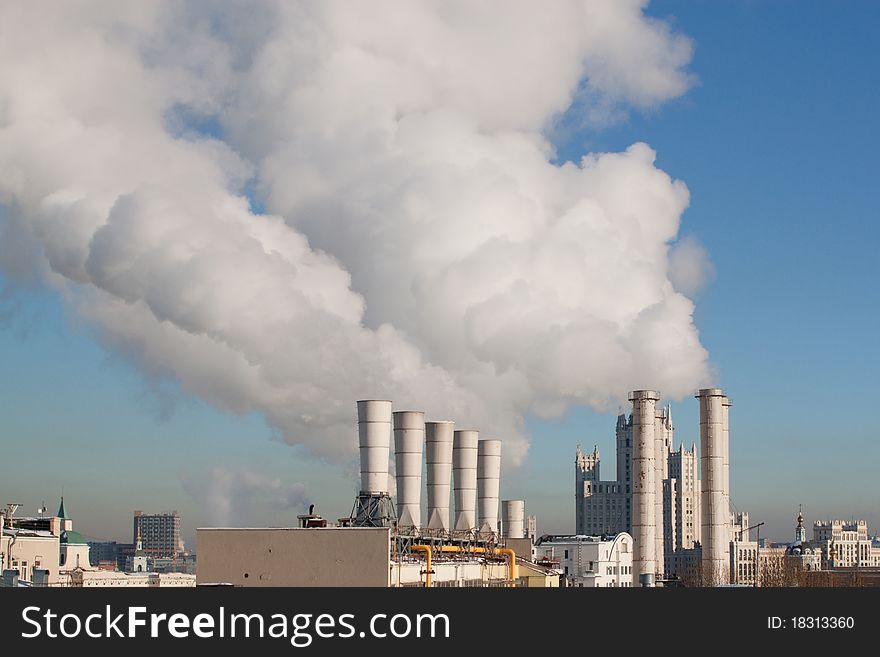 Smoke from pipes against the blue sky