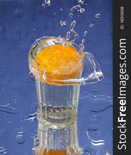 Orange and splash water over blue background