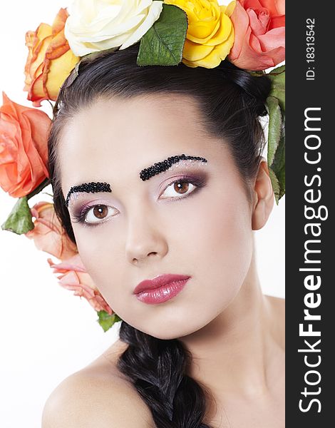 Portrait of young beautiful woman with roses in hair, on white background