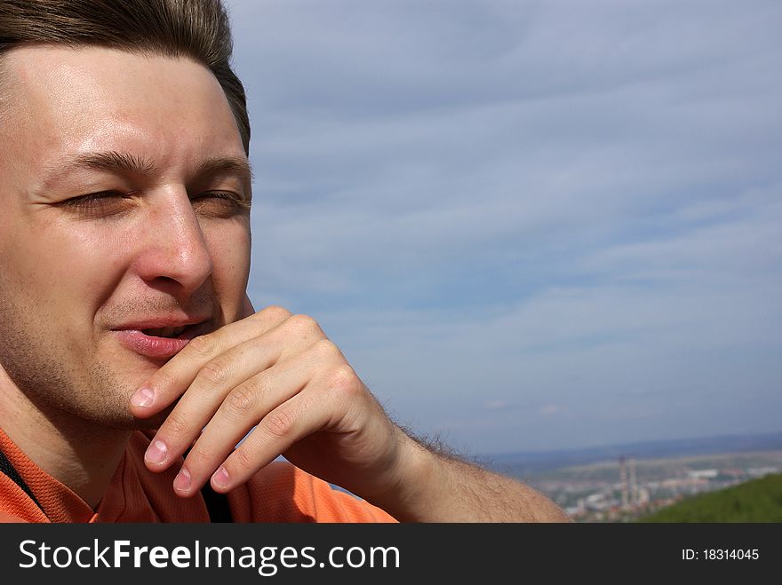 Portrait of a handsome young man with nice scenery of town as a background. Close-up. Portrait of a handsome young man with nice scenery of town as a background. Close-up.