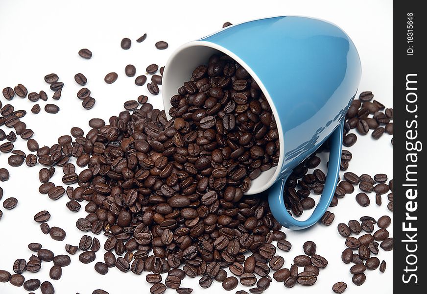 The image shows a part of a coffee cup filled with coffee beans