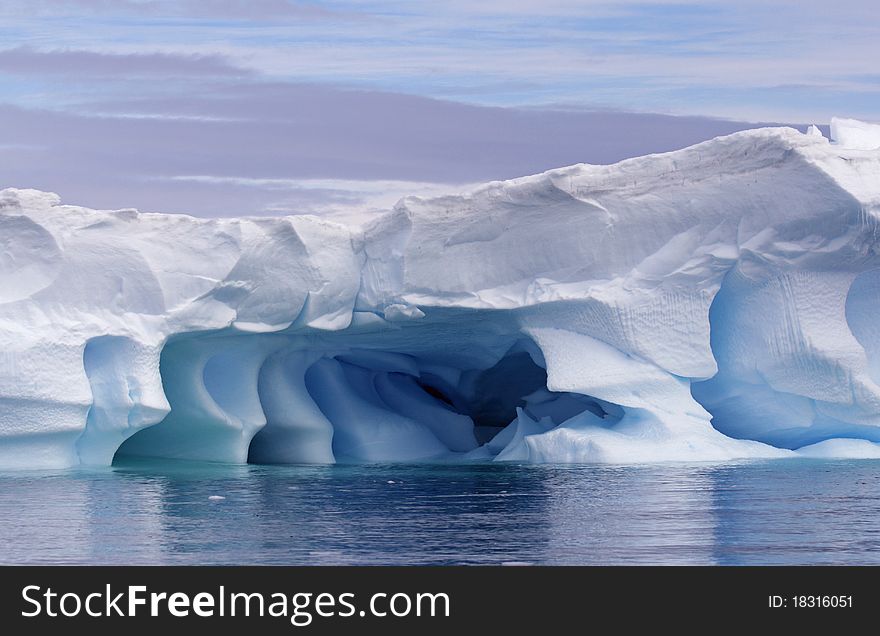 Blue iceberg in Antarctica reflected in sea