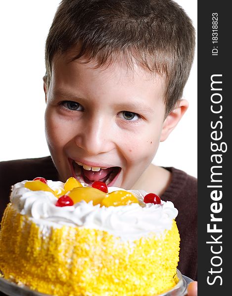 Boy eats a tasty cake isolated on white