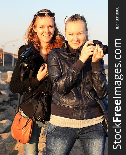 Portrait of two girls with a camera and tripod. Portrait of two girls with a camera and tripod.