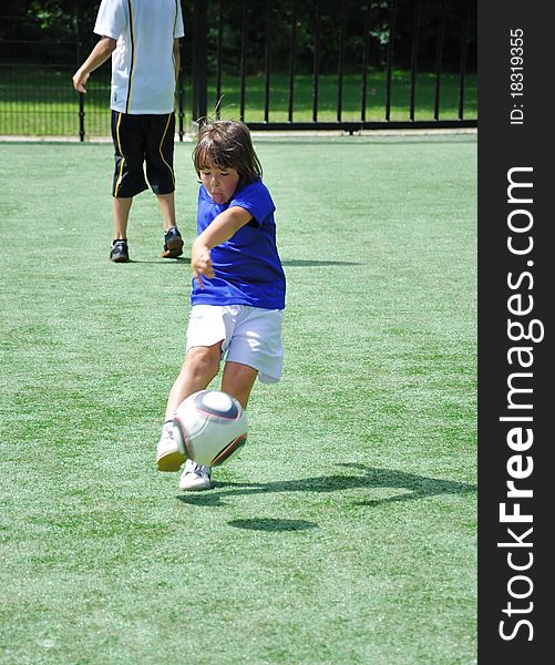 Young boy shooting soccer ball. Young boy shooting soccer ball