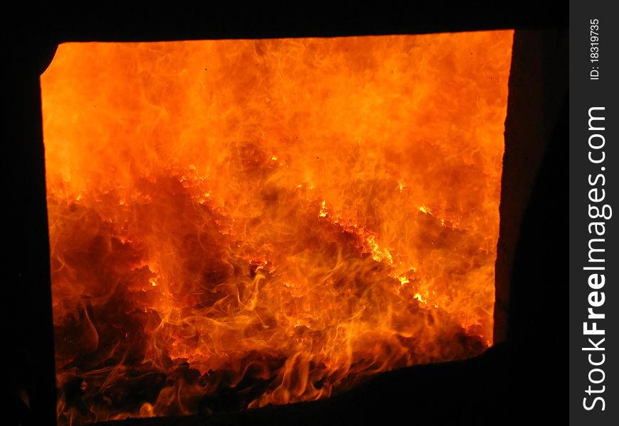 Fire in the coal boiler grate visible through an open manhole. Fire in the coal boiler grate visible through an open manhole