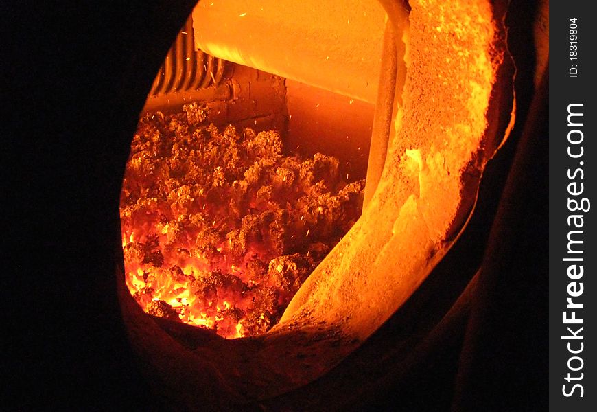 Fire in the coal boiler grate visible through an open manhole. Fire in the coal boiler grate visible through an open manhole