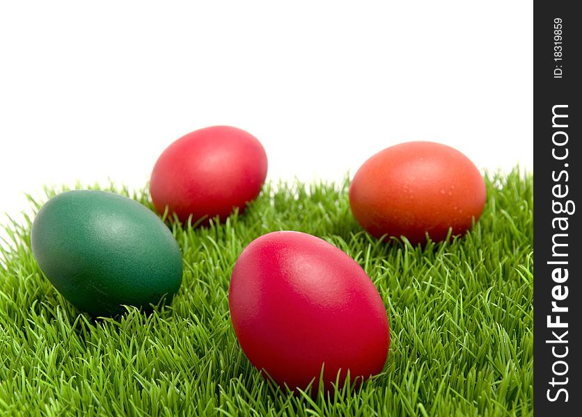 Colorful Easter eggs on green grass, with copy space