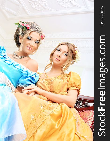 Two beautiful women in medieval era dresses.