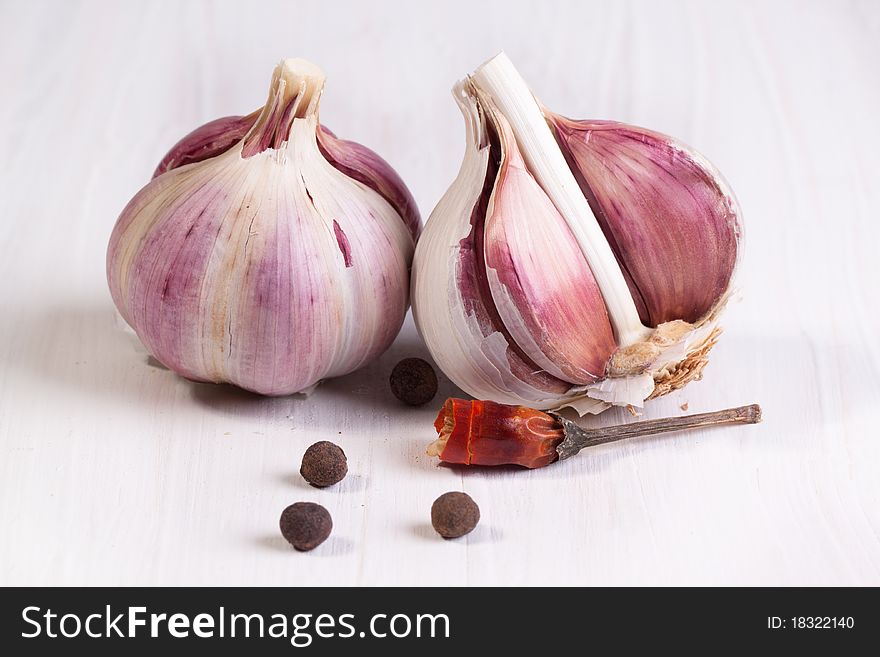 Garlic and pepper on white table