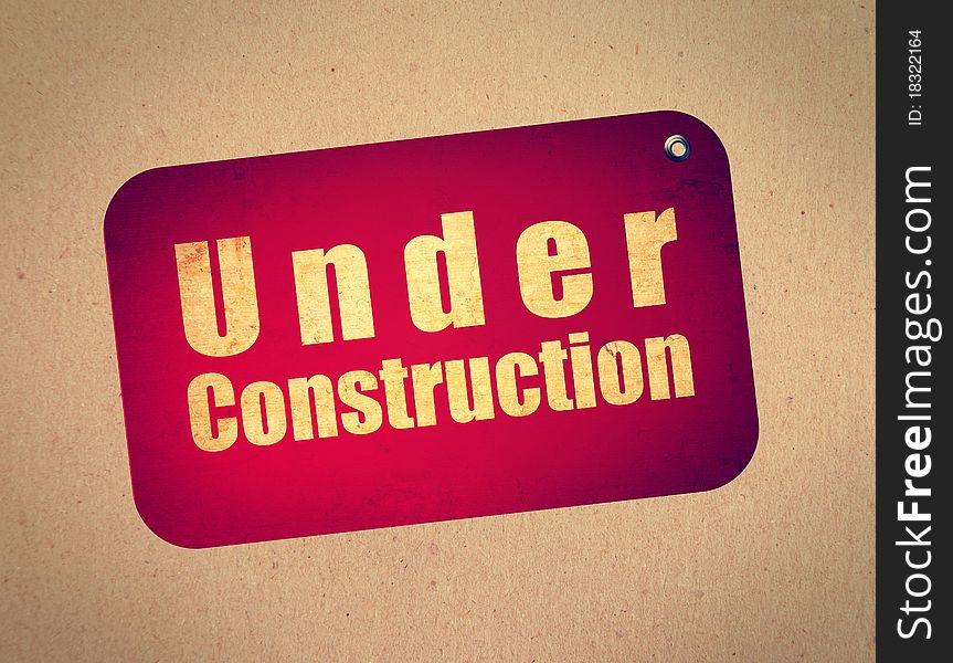 Red billboard with under construction text over wooden background