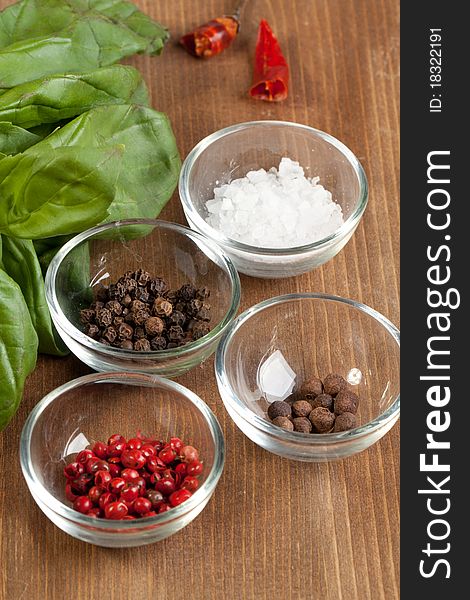 Salt and pepper's mix with fresh herb on the wooden desk