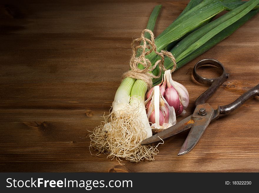 Onion, garlic and old scissors on a wooden table. Onion, garlic and old scissors on a wooden table