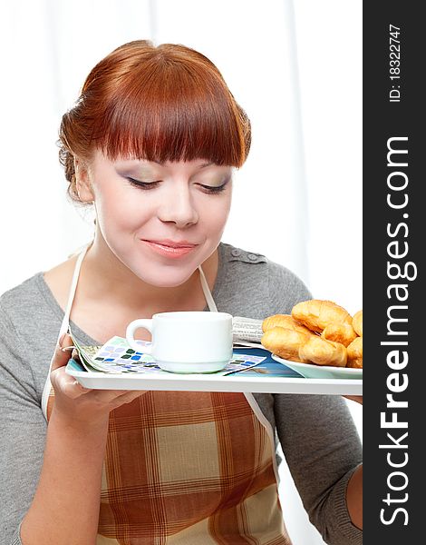 Housewife holding tray with breakfast over white