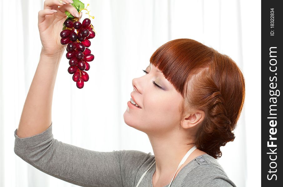 Ginger housewife holding grape