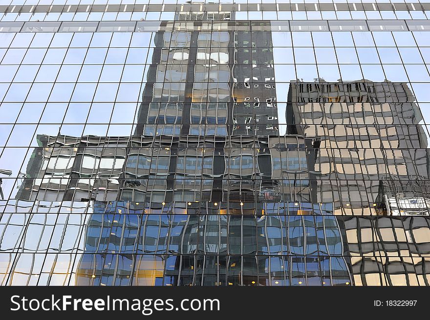 A shot of buildings reflecting from glass window building. A shot of buildings reflecting from glass window building