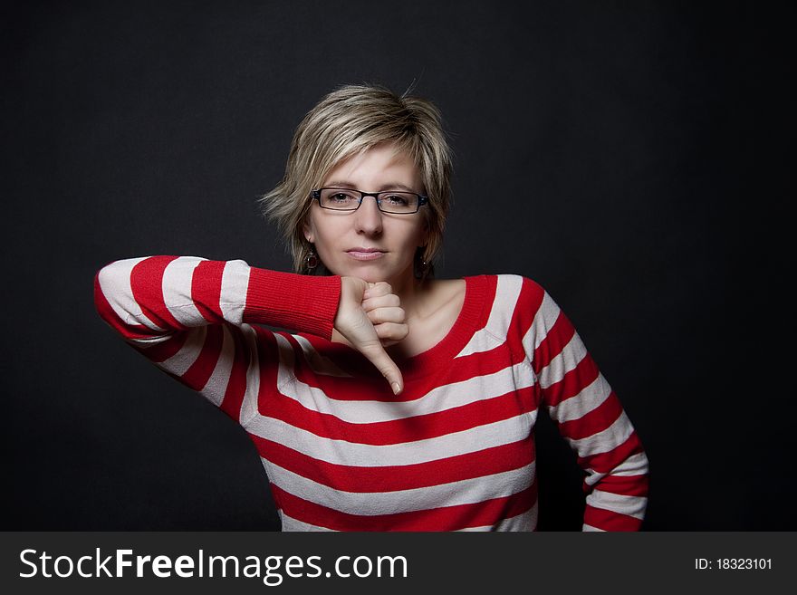 Portrait of attractive woman on black background showing thumb down. Portrait of attractive woman on black background showing thumb down