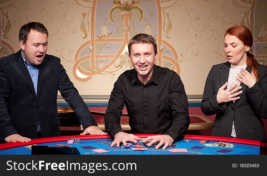 Group of people play poker on blue table