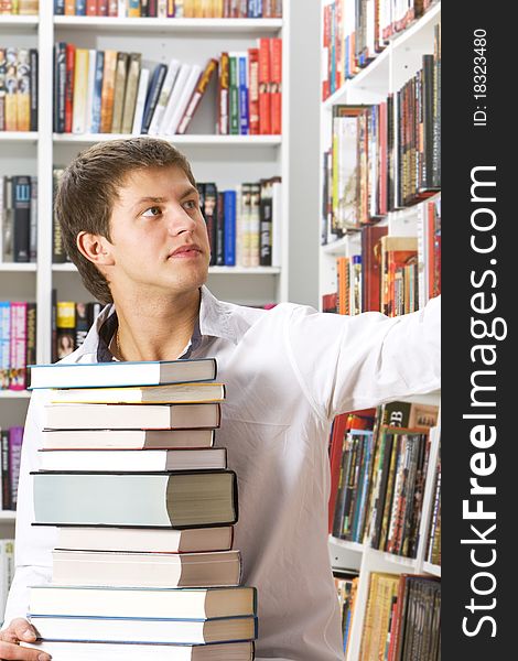 Young man choosing books in the library