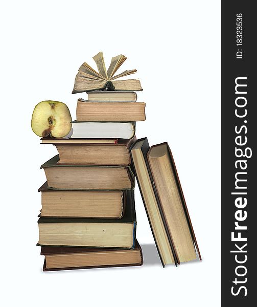 A stack of old books at the bottom of the big, small on top, on the one of them sliced apple. A stack of old books at the bottom of the big, small on top, on the one of them sliced apple