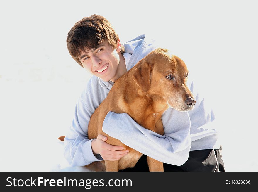 Teenage boy outdoor portrait in the snow with his labrador retriever. Teenage boy outdoor portrait in the snow with his labrador retriever