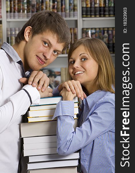 Young couple with stack of books in the booksop. Young couple with stack of books in the booksop