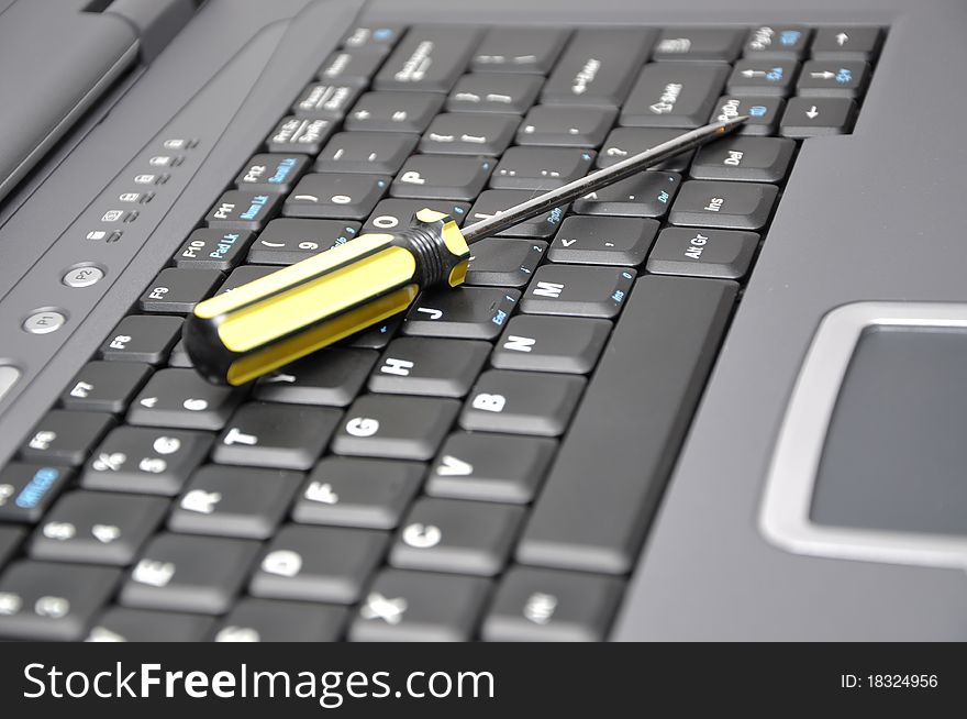 Close up screwdriver and laptop. Close up screwdriver and laptop