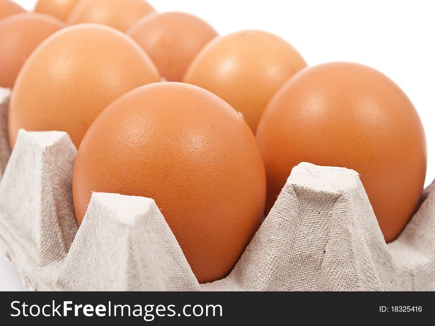 Brown eggs in box on white