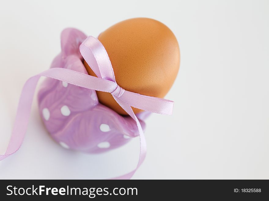Brown easter egg in eggcup with ribbon