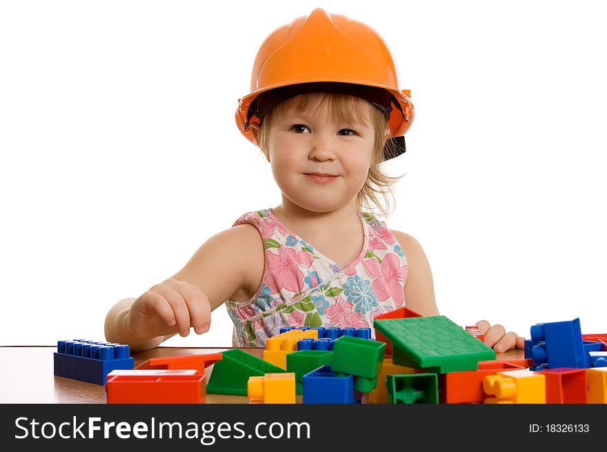 The little girl in a helmet plays on white