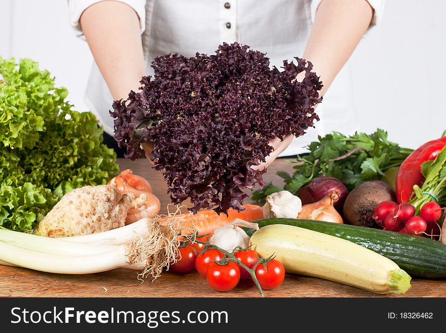 Woman hands showing fresh salad with mixed vegetable.