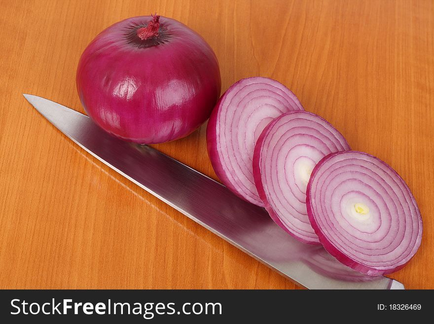 Red onion, slices and knife on the kitchen board. Red onion, slices and knife on the kitchen board