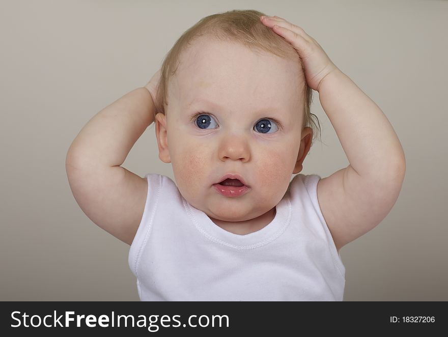 Cute baby boy with hands on head