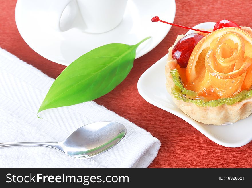 Cupcake with jelly and fruits and a cup of coffee