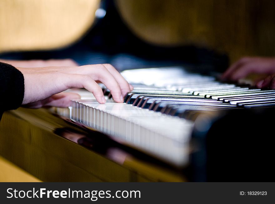 The fingers are playing the piano keyboard. The fingers are playing the piano keyboard
