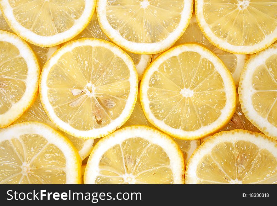 Some slices of ripe yellow lemons background. Some slices of ripe yellow lemons background