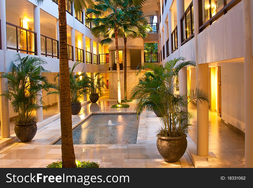 The indoor water fountain and stretch of palm tree and potting. The indoor water fountain and stretch of palm tree and potting