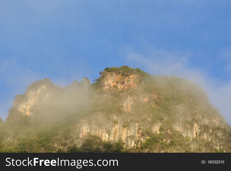 The beautiful limestone mountain cover with mist and blue sky.