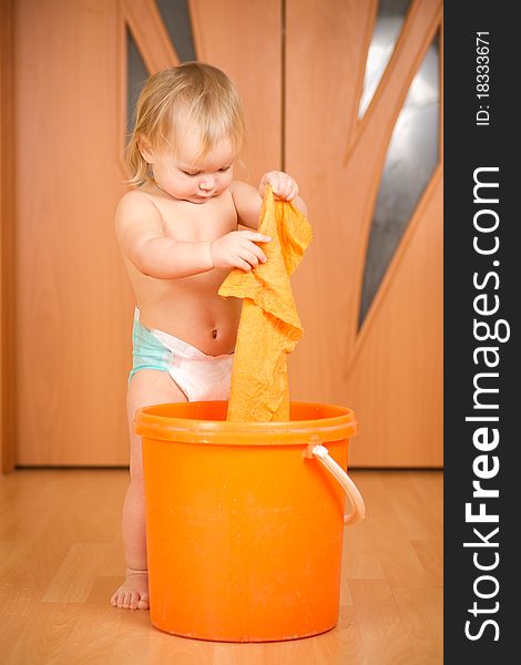Adorable baby washing rug in orange pail