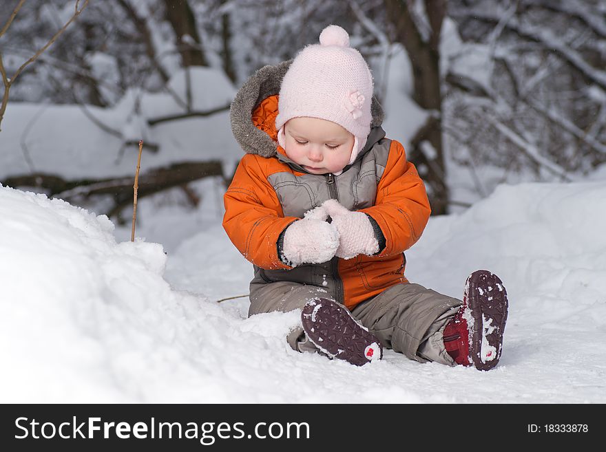 Cute Baby Sit On Snow In Forest And Dig Snow