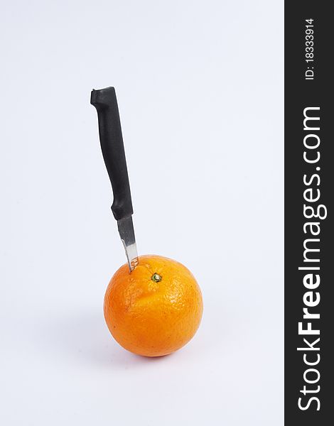 A black knife stab on an orange. A black knife stab on an orange.