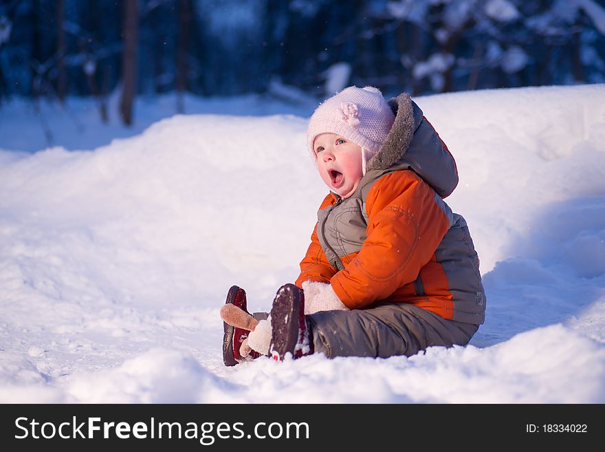 Cute adorable baby sit on snow in winter park holding small toy dog and yawn. Cute adorable baby sit on snow in winter park holding small toy dog and yawn