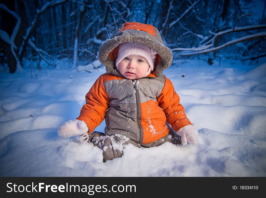 Adorable baby sit in deep snow in park